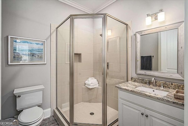bathroom with a shower stall, toilet, crown molding, and vanity
