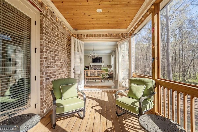 sunroom / solarium featuring a chandelier
