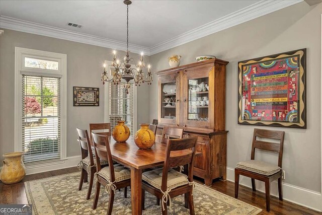 dining area featuring crown molding, wood finished floors, baseboards, a notable chandelier, and visible vents
