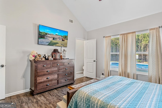 bedroom with dark wood-type flooring and high vaulted ceiling