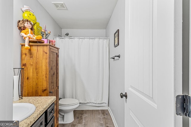 full bathroom with shower / tub combo with curtain, vanity, hardwood / wood-style flooring, and toilet