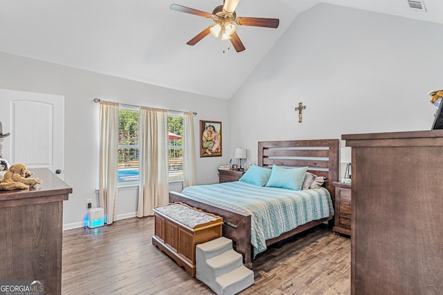 bedroom with ceiling fan, high vaulted ceiling, and hardwood / wood-style floors