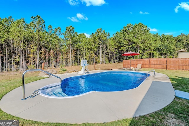 view of pool with a patio and a lawn