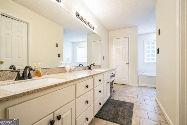 bathroom with vanity, a bathing tub, a wealth of natural light, and tile patterned floors