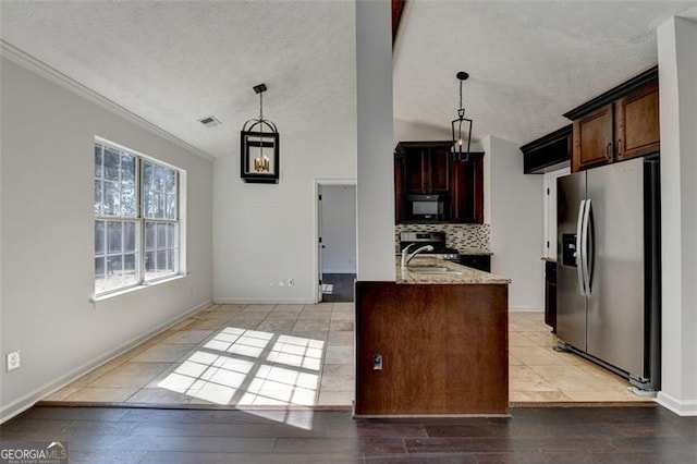 kitchen featuring stainless steel refrigerator with ice dispenser, light stone countertops, sink, and pendant lighting