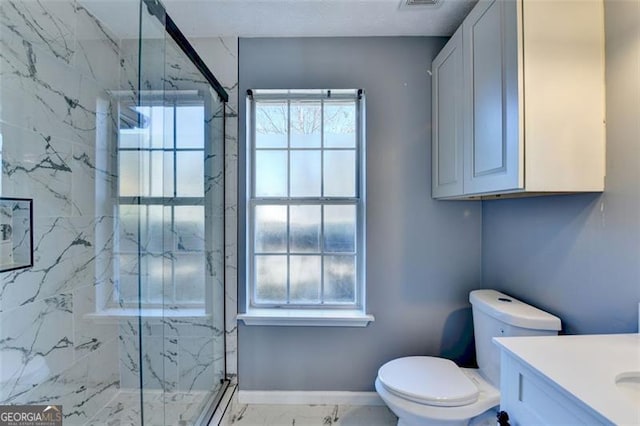 bathroom featuring vanity, toilet, and a shower with door