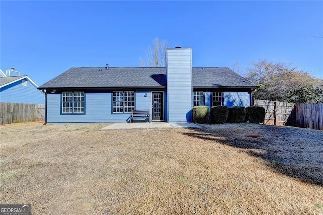 back of property with a lawn and a patio