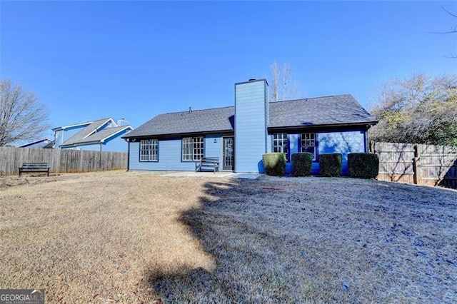 rear view of property featuring a yard