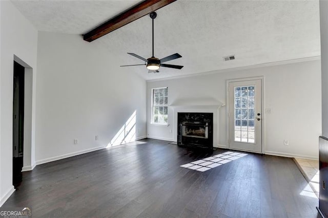 unfurnished living room with a wealth of natural light, lofted ceiling with beams, dark hardwood / wood-style floors, and a textured ceiling