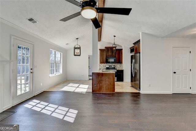 kitchen featuring appliances with stainless steel finishes, a center island, vaulted ceiling, and hanging light fixtures