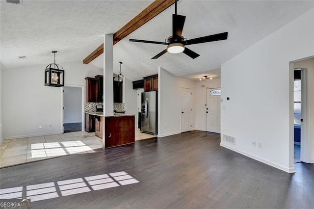 unfurnished living room featuring vaulted ceiling with beams, light hardwood / wood-style floors, and ceiling fan