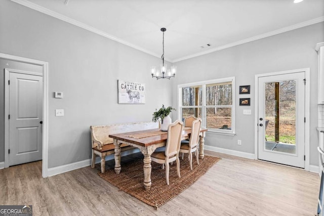 dining room with ornamental molding, a chandelier, and light wood-type flooring