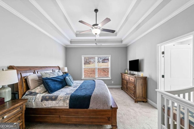 carpeted bedroom with ceiling fan, ornamental molding, and a tray ceiling