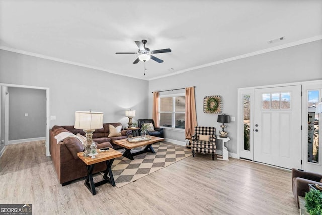 living room with ornamental molding, ceiling fan, and light wood-type flooring