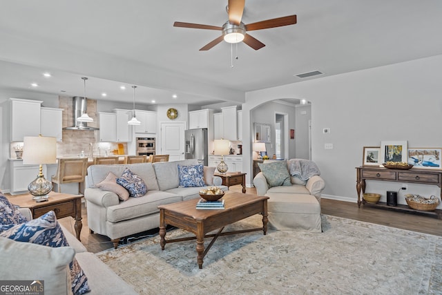 living room with hardwood / wood-style flooring, ceiling fan, and sink