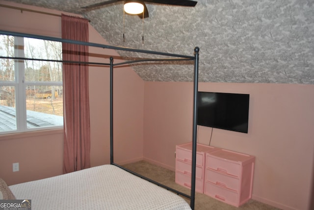 carpeted bedroom with vaulted ceiling and multiple windows