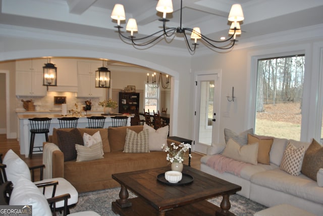 living room with crown molding, coffered ceiling, beam ceiling, and a chandelier