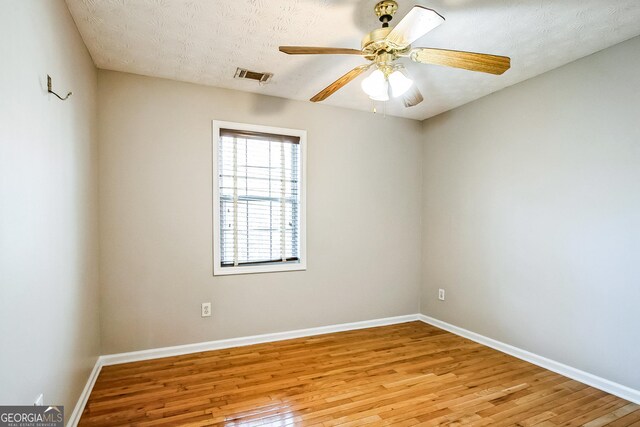 spare room featuring ceiling fan, a textured ceiling, and light hardwood / wood-style floors