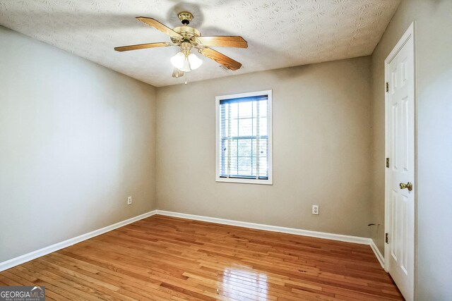 unfurnished room featuring a textured ceiling, light hardwood / wood-style floors, and ceiling fan