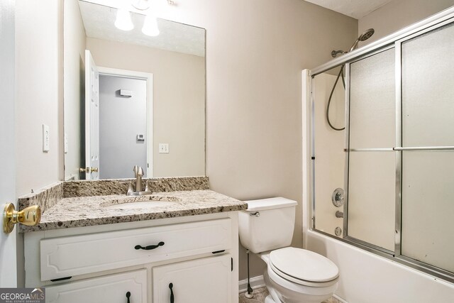 full bathroom featuring vanity, bath / shower combo with glass door, and toilet