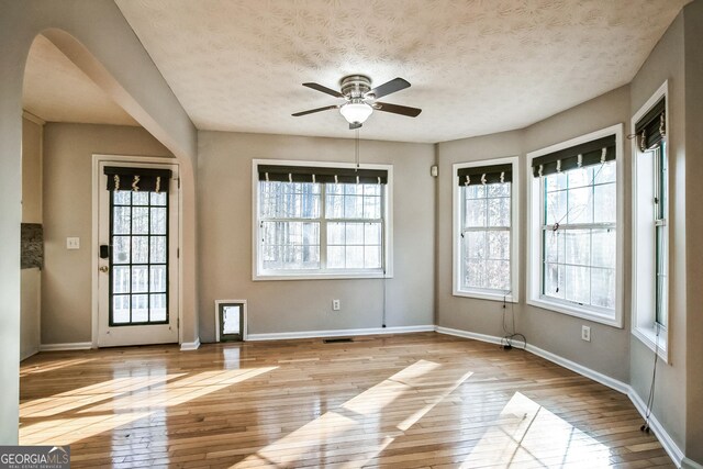 interior space featuring ceiling fan, a textured ceiling, and light hardwood / wood-style floors