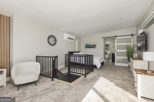 carpeted bedroom featuring a barn door and an AC wall unit