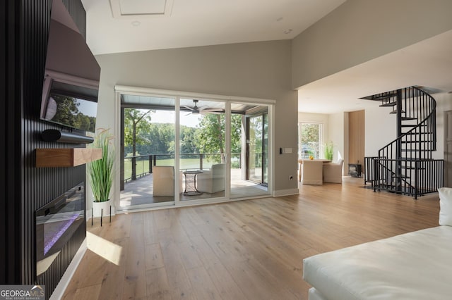 interior space featuring high vaulted ceiling, a fireplace, and light wood-type flooring