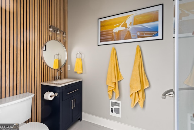 bathroom featuring vanity, heating unit, and toilet