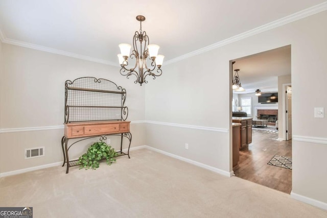 interior space with crown molding, ceiling fan with notable chandelier, and light carpet