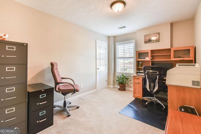 home office featuring light carpet and a textured ceiling