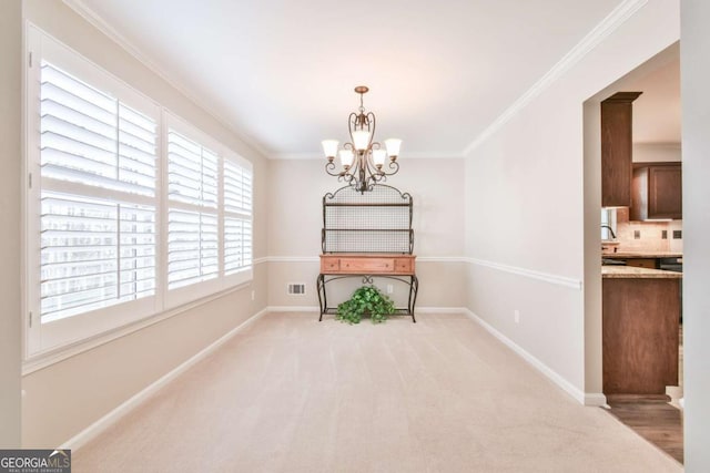 unfurnished dining area featuring crown molding, light carpet, and a notable chandelier