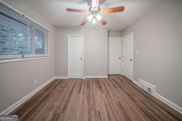 unfurnished bedroom featuring dark hardwood / wood-style floors and ceiling fan