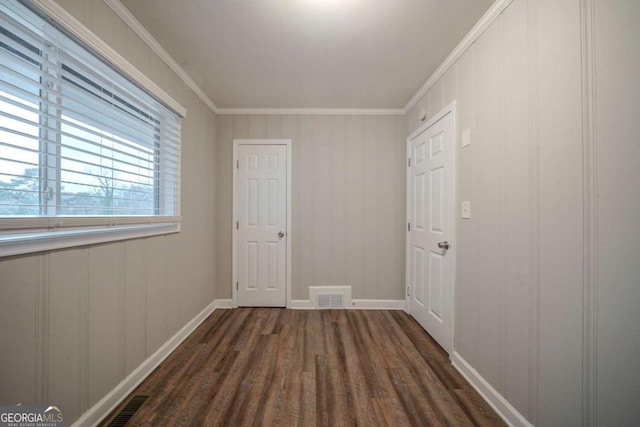 hall with dark wood-type flooring and crown molding