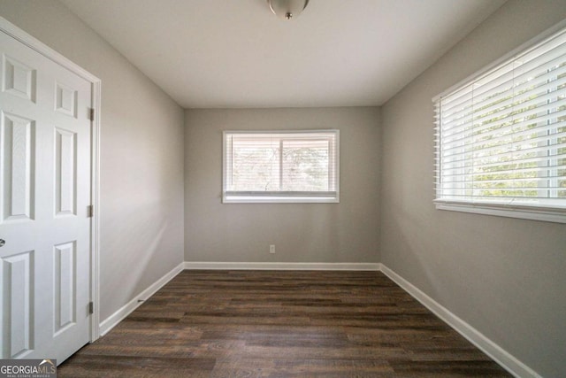 spare room featuring plenty of natural light and dark hardwood / wood-style floors