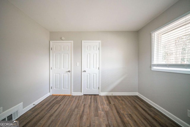 unfurnished bedroom with dark hardwood / wood-style floors