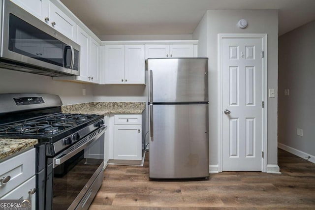 kitchen featuring white cabinetry, stainless steel appliances, and light stone countertops