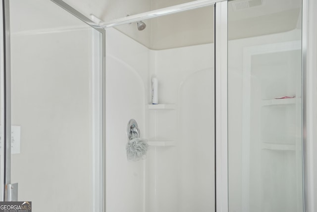 bathroom featuring a shower with door