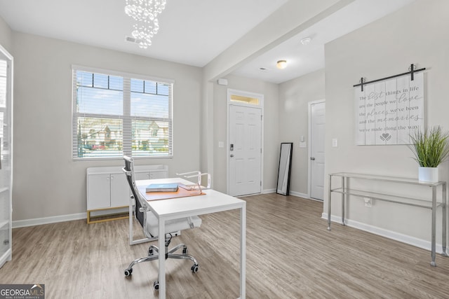 home office featuring light hardwood / wood-style floors and a notable chandelier