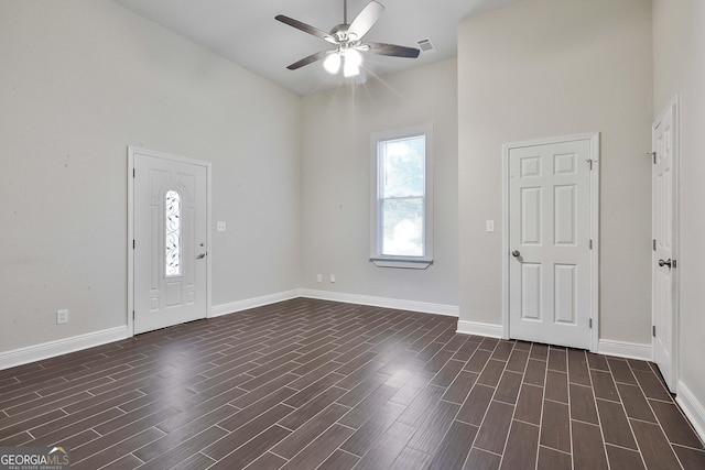 foyer featuring ceiling fan, a towering ceiling, and dark hardwood / wood-style flooring