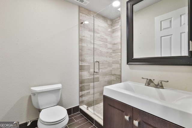 bathroom featuring vanity, toilet, and walk in shower