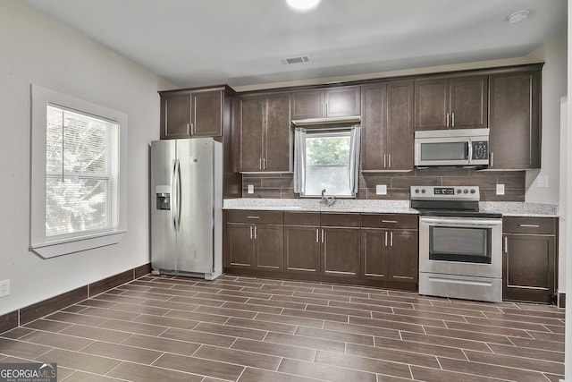 kitchen with stainless steel appliances, sink, and dark brown cabinetry