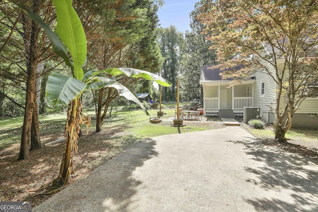 view of yard with central AC and a porch