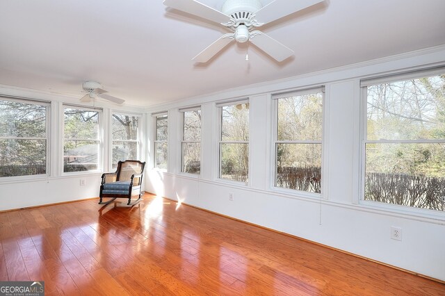 unfurnished sunroom featuring ceiling fan