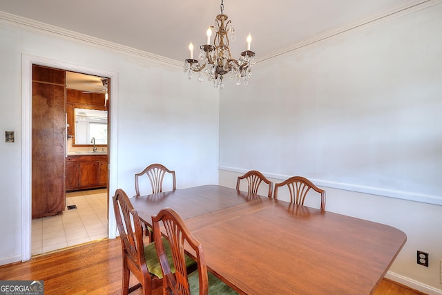 dining room with sink, crown molding, and light tile patterned flooring