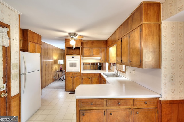 kitchen featuring sink, white appliances, kitchen peninsula, and ceiling fan