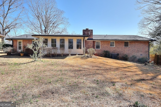 rear view of property with a yard and central air condition unit