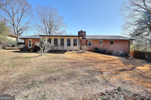 rear view of property featuring a lawn