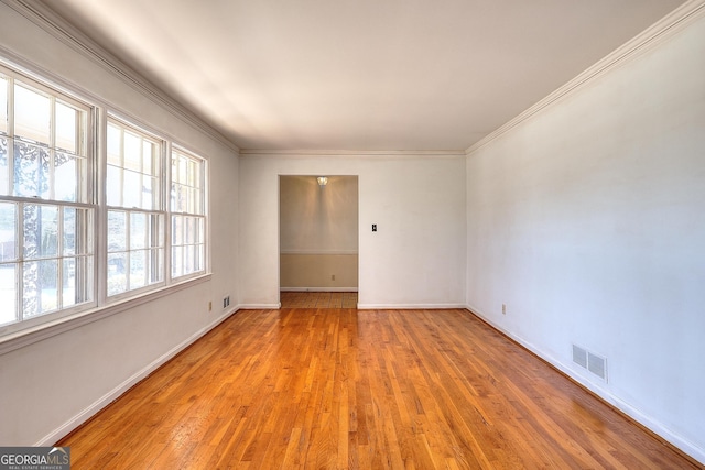 spare room featuring light hardwood / wood-style flooring and ornamental molding