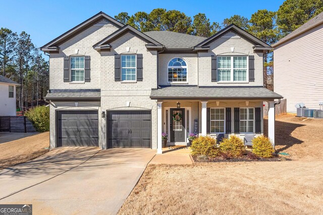 view of front of home featuring a garage, central AC, and covered porch