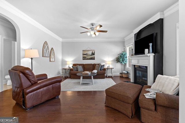 living area featuring crown molding, a ceiling fan, and dark wood-style flooring